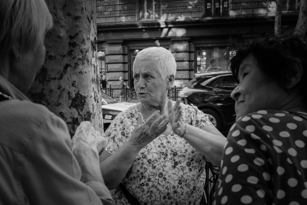 Photographer interviewing an elderly Polish woman at her kitchen table